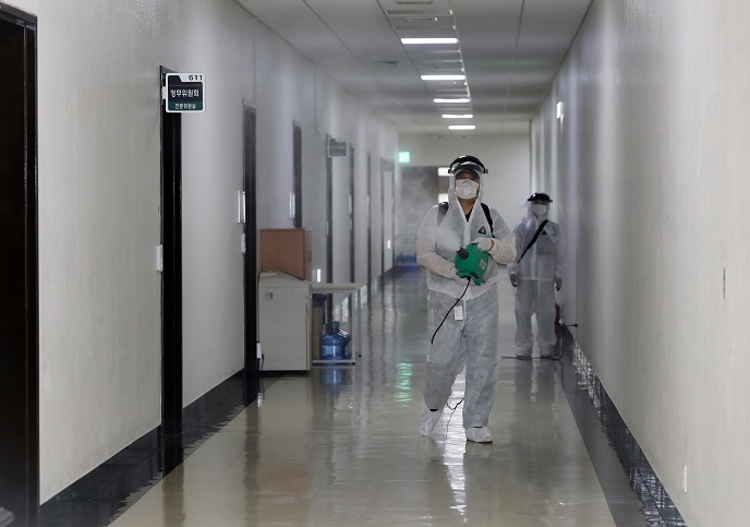 This photo, provided by the National Assembly on Sept. 7, 2020, shows a quarantine official disinfecting the parliamentary building in Seoul after a journalist covering the assembly tested positive for the new coronavirus.