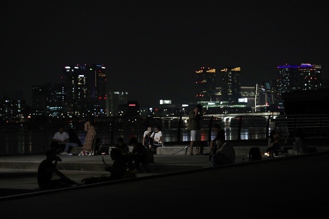 People gather along the banks of the Han River that flows through Seoul, on Sept. 8, 2020. The Seoul metropolitan government has not prevented people from using the numerous parks and picnic areas, but has closed off some popular sections, as part of strict social distancing measures to prevent the spread of the new coronavirus. (Yonhap)