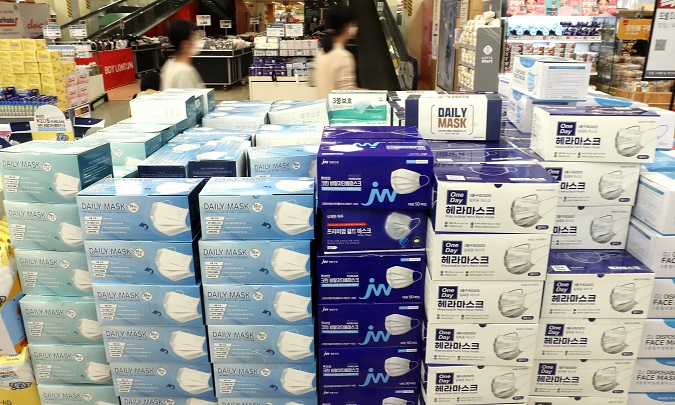 Shoppers at a large discount store in Seoul pass by face masks on Sept. 10, 2020. The government said it will allow local manufacturers to export surgical and anti-droplet face masks starting next week. (Yonhap)