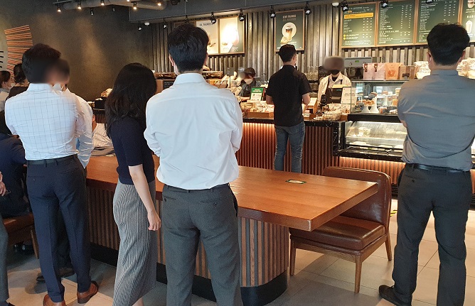 Visitors at a Starbucks branch in Yeouido, in western Seoul, wait for their coffees on Sept. 14, 2020. (Yonhap)