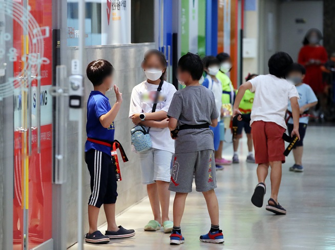 Children chat in front of a reopened private education institute in Seoul on Sept. 14, 2020, the first day of the easing of toughened social distancing guidelines, as new COVID-19 cases noticeably declined. Such private institutions were shut down over the previous two weeks amid a resurgence of the virus. (Yonhap)