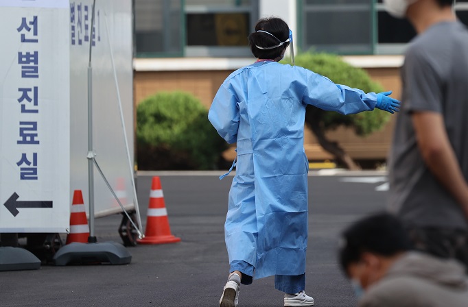 A worker guides visitors at a makeshift clinic in central Seoul on Sept. 15, 2020. (Yonhap)