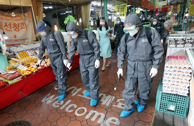 Sanitary workers disinfect the floor of a traditional market in Incheon, west of Seoul, on Sept. 15, 2020. (Yonhap)