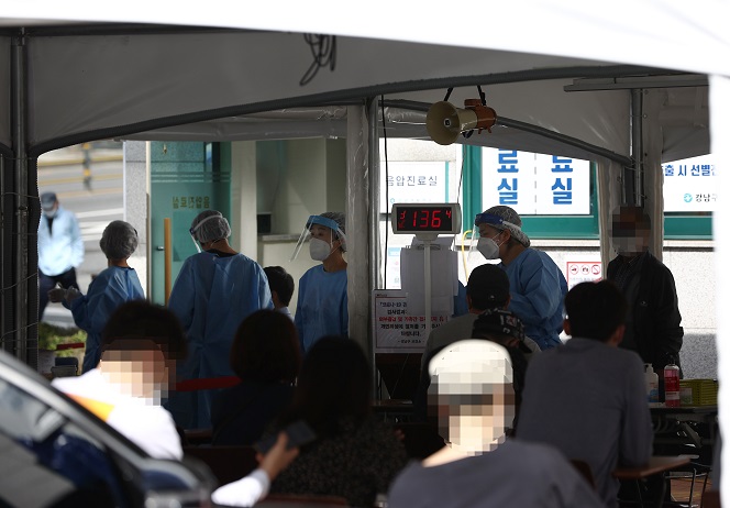 Citizens wait to receive new coronavirus tests at a makeshift clinic located in southern Seoul on Sept. 21, 2020. (Yonhap)
