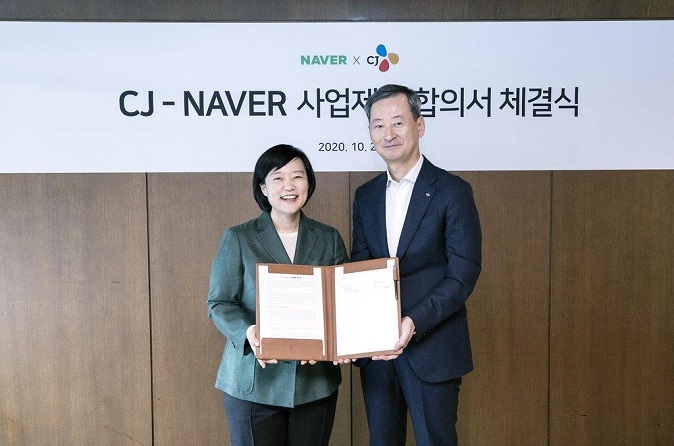 Han Seong-sook (L), CEO of Naver, and Choi Eun-seok, head of Management Strategy Office of CJ Corp., pose after signing a strategic partnership deal on Oct. 26, 2020, in this photo provided by Naver.