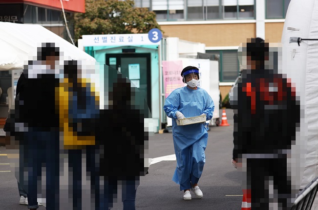 A health worker clad in protective gear prepares to work at a COVID-19 screening clinic on Oct. 7, 2020. (Yonhap)