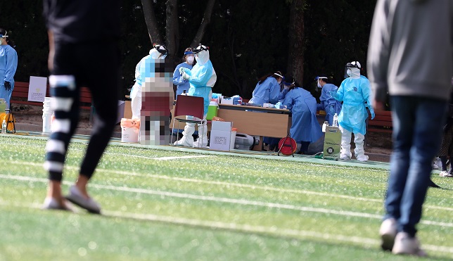This photo taken on Oct. 9, 2020, shows students and teachers of Daejeon Duwon Middle and High School in Daejeon, 160 kilometers south of Seoul, receiving coronavirus tests after two students at the middle school and three students at the high school tested positive for COVID-19 the previous day. (Yonhap)