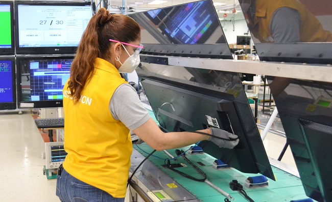 This photo, provided by LG Electronics Inc. on Nov. 16, 2020, shows a worker checking OLED TVs at the company's plant in Reynosa, northeastern Mexico. 