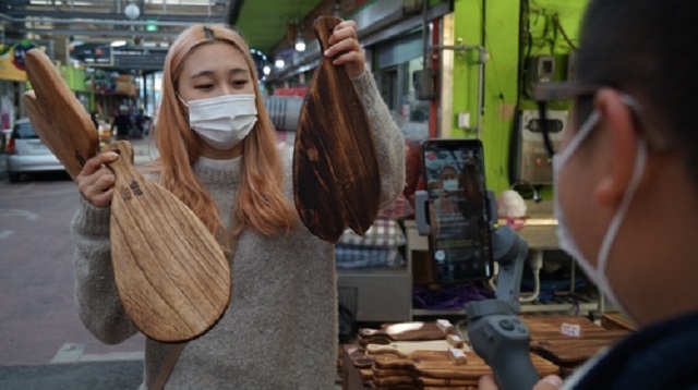Oh Mun-hyun (L), 23, and Kim Jin-deok, 20, live-stream their shopping on behalf of their viewers to help merchants at traditional five-day markets. (Yonhap)