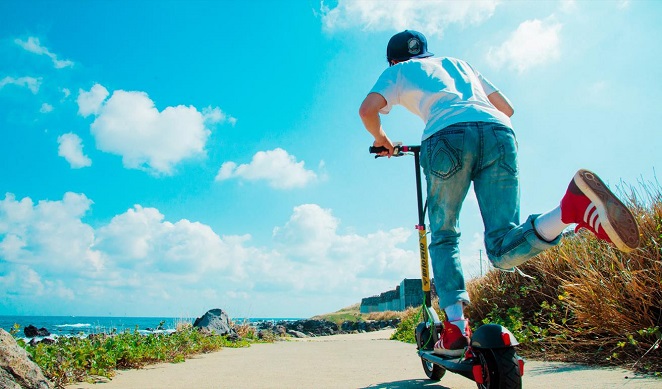 This photo provided by an electric scooter sharing platform on Aug. 11, 2020, shows a tourist on Jeju Island riding an e-scooter. 