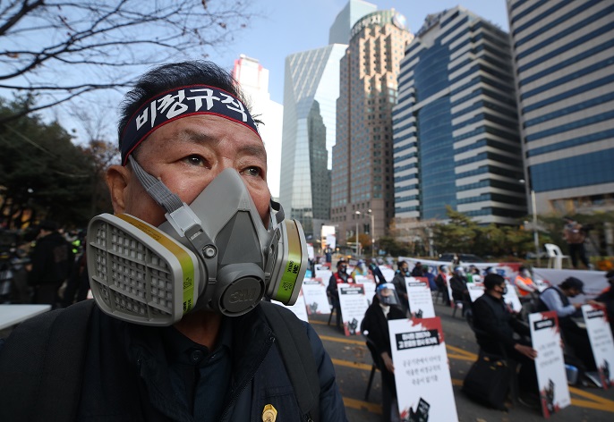 A man wearing a gas mask participates in a rally organized by the Korean Confederation of Trade Unions in Yeouido, southern Seoul, on Nov. 14, 2020. (Yonhap)