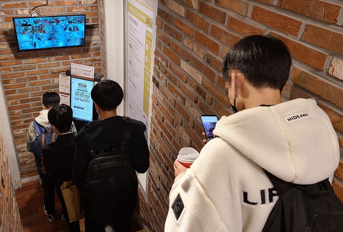 Students enter a study cafe in Seoul on Nov. 16, 2020. Health authorities vowed to step up antivirus measures at private institutions and study cafes in the run up to the nationwide college exam. (Yonhap)