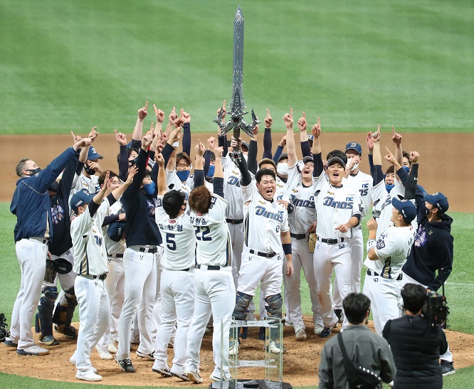 Members of the NC Dinos celebrate their Korean Series championship following a 4-2 victory over the Doosan Bears in Game 6 at Gocheok Sky Dome in Seoul on Nov. 24, 2020. Team captain Yang Eui-ji (C) is holding up a replica of "Execution Sword," a highly valued item from the game "Lineage" by NCSOFT. (Yonhap)