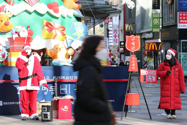 Officials of South Korea's Salvation Army hold its annual charity pot campaign in Seoul's shopping district of Myeongdong on Dec. 20, 2020, amid the new coronavirus outbreak. (Yonhap)