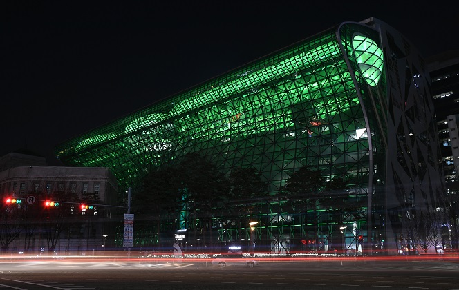 This photo, provided by the Seoul city government, shows its city hall building glowing in green.