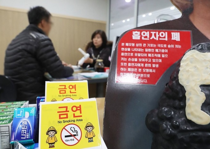 A smoker (L) consults with an official over stopping smoking at a community health center in Suwon, south of Seoul, on Jan. 2, 2020. (Yonhap)