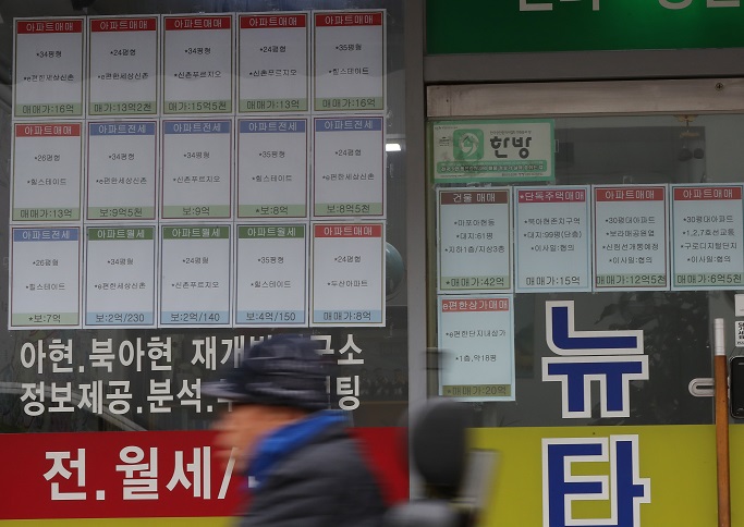 A pedestrian passes by a real estate brokerage office in western Seoul on Nov. 2020. (Yonhap)
