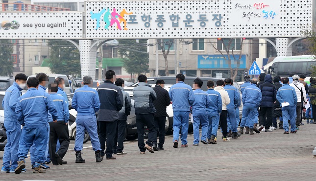 Workers at the Pohang steel industrial complex, 374 kilometers southeast of Seoul, line up in front of a screening center set up at the Pohang Sports Complex to take coronavirus tests on Dec. 11, 2020. (Yonhap)