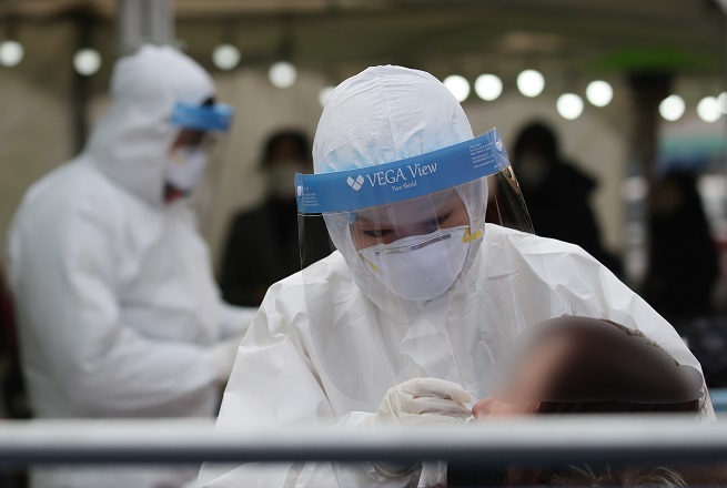 A medical worker conducts a COVID-19 test at a makeshift virus testing clinic on Dec. 22, 2020. (Yonhap)