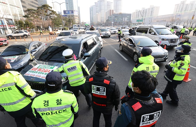 Police block activists' drive-thru protest in southern Seoul on Dec. 26, 2020. (Yonhap)