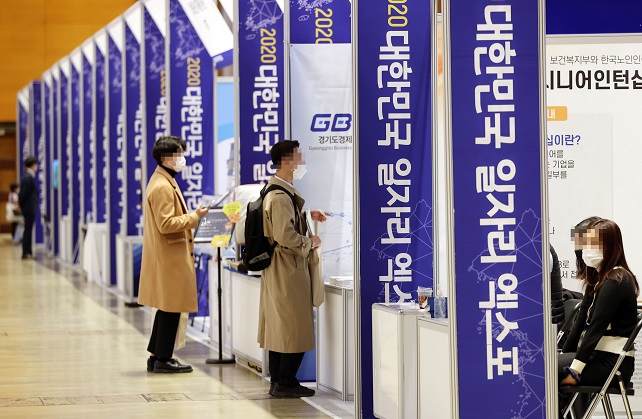 In this file photo taken Nov. 11, 2020, jobseekers look around booths of a job fair in the Convention and Exhibition Center in southern Seoul. (Yonhap)