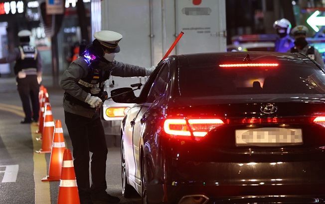 This file photo, taken on Nov. 27, 2020, shows a police officer conducting a breathalyzer test on a car driver in Seoul. (Yonhap)