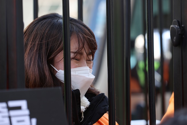 In this file photo, a member of a Pilates business owner association sheds tears during a press briefing held in front of the ruling Democratic Party's office in western Seoul on Jan. 5, 2021, to raise the issue of fairness regarding the government's social distancing guidelines for indoor sports facilities. (Yonhap)
