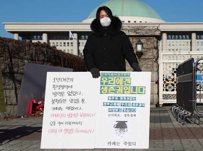 A member of a national cafe owners' association protests the government's coronavirus-related business restrictions as part of a relay demonstration outside the National Assembly in Seoul on Jan. 6, 2021. (Yonhap)