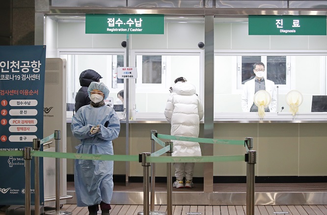 In this file photo, people apply for COVID-19 tests at a testing station set up for departing passengers at the second terminal of Incheon International Airport, west of Seoul, on Jan. 8, 2021. (Yonhap)