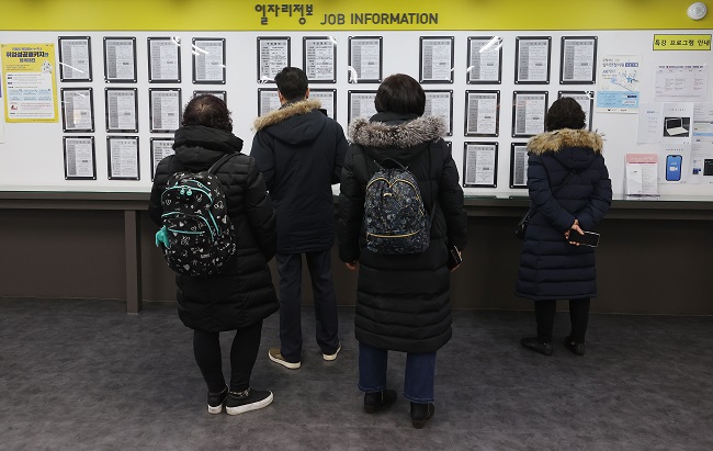 People stand in line to attend a presentation on how to receive unemployment benefits at a labor welfare center in Seoul on Jan. 13, 2021. (Yonhap)