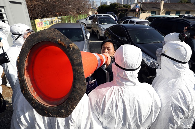 A citizen stages a protest against the TCS Ace International School over mass COVID-19 infections among its students and teachers in front of the school in Gwangju on Jan. 27, 2021. (Yonhap)