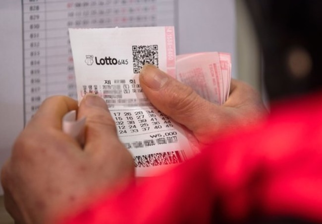 This photo taken on Jan. 22, 2019, shows an individual holding a Lotto ticket. (Yonhap)