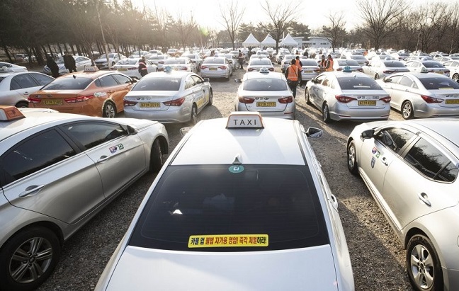 Taxis are parked at a riverside park in Seoul on Feb. 18, 2019, to have their meters replaced. (Yonhap)