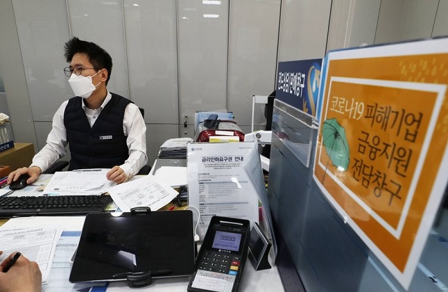 In this file photo, taken on April 1, 2020, a bank official at Shinhan Bank in Seoul holds an interview with a customer seeking a special low-interest loan for small and medium-sized firms hit by the new coronavirus outbreak. (Yonhap)