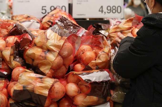 In this file photo, a shopper picks up a bag of onions at a supermarket in Seoul on Jan. 15, 2021. (Yonhap)