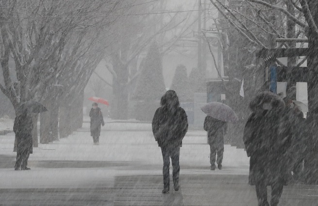 This file photo, taken Jan. 28, 2021, shows people walking in heavy snow in Seoul. (Yonhap)