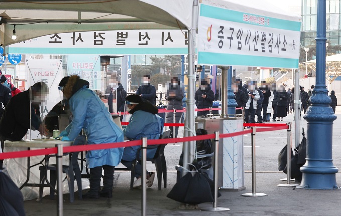 People line up to take a coronavirus test at a clinical center set up in front of Seoul Station in central Seoul on Feb. 3, 2021. (Yonhap)