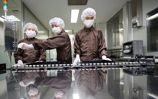 Workers look at bottles of pharmaceutical giant Celltrion Inc.'s COVID-19 antibody treatment, CT-P59, on a production line at a plant in Incheon, west of Seoul, on Feb. 9, 2021. (Yonhap)