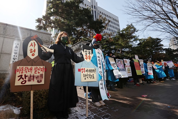 This Feb. 17, 2021, file photo shows people calling for stern punishment against two parents, who allegedly abused their 16-month-old adopted daughter to death in October, in front of the Seoul Southern District Court. (Yonhap)