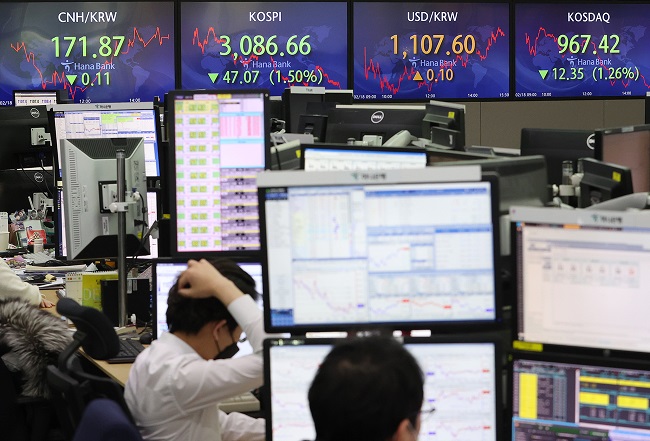 Electronic signboards at a Hana Bank dealing room in Seoul show the benchmark Korea Composite Stock Price Index (KOSPI) closed at 3,086.66 points on Feb. 18, 2021, down 47.07 points, or 1.5 percent, from the previous session's close. (Yonhap)