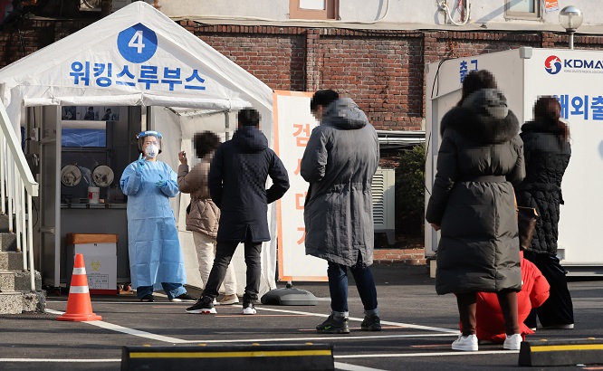 Citizens wait in line to receive COVID-19 tests at a testing site of the National Medical Center in central Seoul on Feb. 21, 2021. (Yonhap)