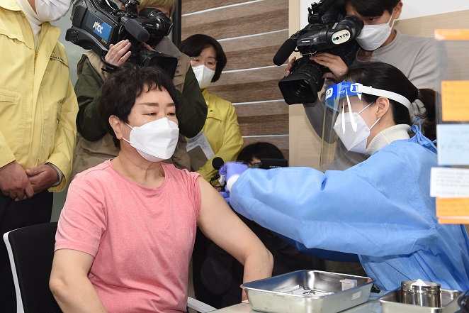 A 61-year-old health care worker from a nursing facility receives the country's first COVID-19 vaccine at a public health center in Seoul on Feb. 26, 2021. (Yonhap)