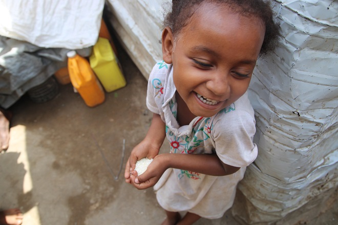 This undated file photo provided by the World Food Programme (WFP) shows a child in Yemen holding a handful of rice donated from South Korea.