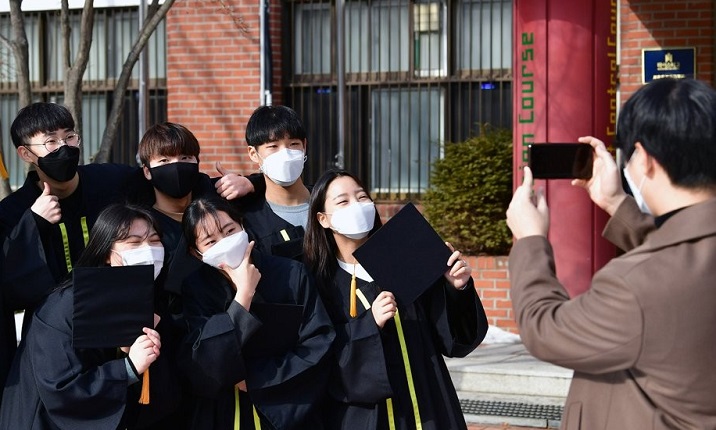 High school students wearing protective masks pose for a photo during a graduation ceremony on Jan. 13, 2021. (Pool photo) (Yonhap)
