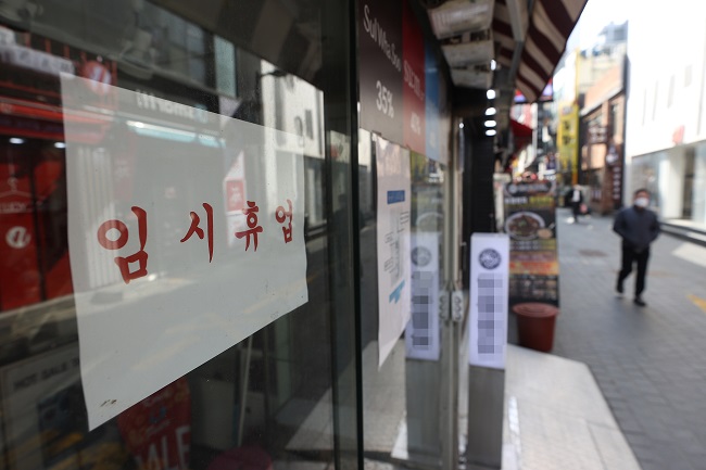 This file photo, taken on March 3, 2021, shows a sign announcing a temporary business closure over the pandemic that was put up at a store in Seoul's shopping district of Myeongdong. (Yonhap)