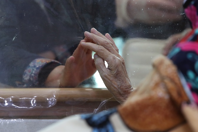 A 90-year-old patient (R) of Gangnam Medical Treatment Hospital in Gwangju, southwestern South Korea, meets with her daughter through a transparent barrier on March 9, 2021. (Yonhap)