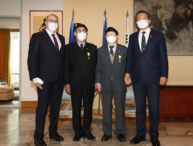French Ambassador to South Korea Philippe Lefort (L) and South Korean veteran affairs minister Hwang Ki-chul (R) pose for a photo with Korean War veterans Park Dong-ha (2nd from L) and Park Mun-joon after awarding them with a military decoration from France at the French Embassy in Seoul on March 11, 2021. (Yonhap)