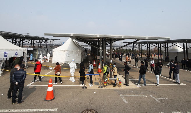 Foreign workers stand in line to get COVID-19 tests in a stadium in Hwaseong, about 50 kilometers south of Seoul, on March 14, 2021. (Yonhap)