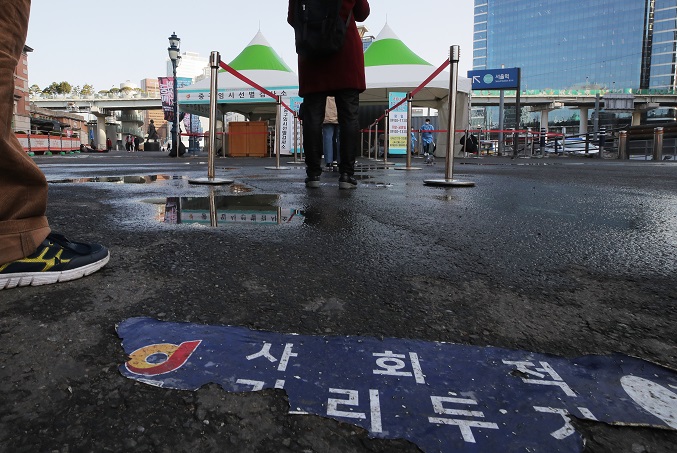 People stand in line to undergo COVID-19 testing at a temporary screening station in front of Seoul Station on March 16, 2021. (Yonhap)