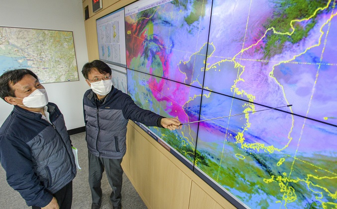 Officials check the moving route of a yellow dust storm originating from the inland deserts in northern China at a Korea Meteorological Administration branch in Suwon, south of Seoul, on March 16, 2021, amid a strong yellow dust advisory across the nation. (Yonhap)